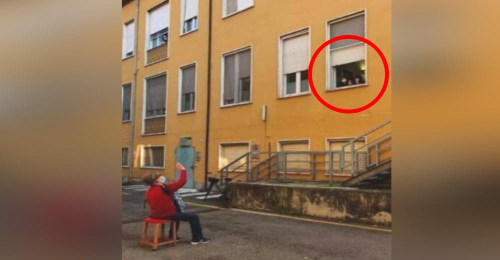 Un abuelito toca el acordeón para ofrecerle una serenata a su esposa desde el patio del hospital