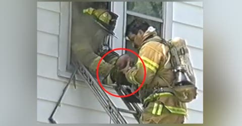 Un bombero intenta con desespero salvar a la niña que acaban de sacar por la ventana